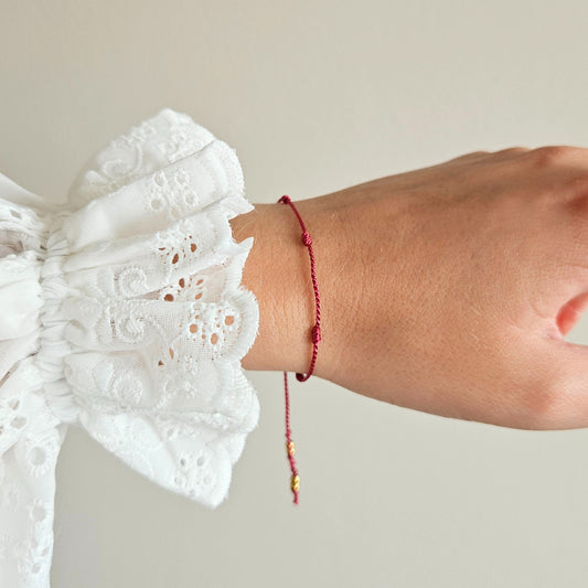 Bransoletka z nici jedwabnej z zawieszką "SEVEN THREADS OF INTENTION" bordowa